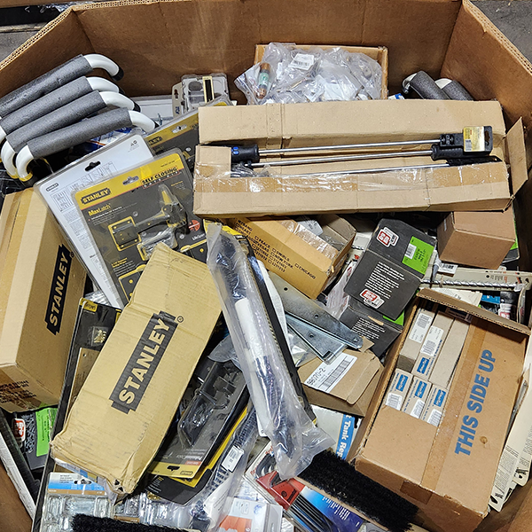 Pile of hardware items including Stanley tools in a cardboard box.